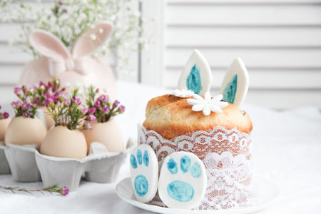 Easter cake in the form of the Easter Bunny and Easter decor with flowers on the tableの写真素材