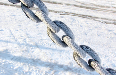 Protective big chain, covered with snow. Large plan.