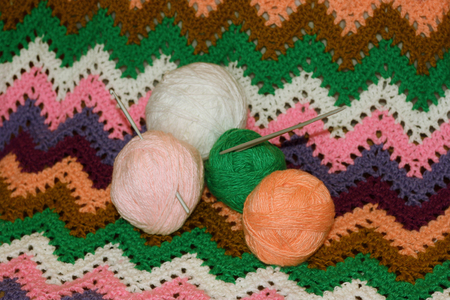 The balls of yarn for knitting, crochet and knitting needles on the associated colored canvas The balls of yarn for knitting, crochet and knitting needles on the associated colored canvas