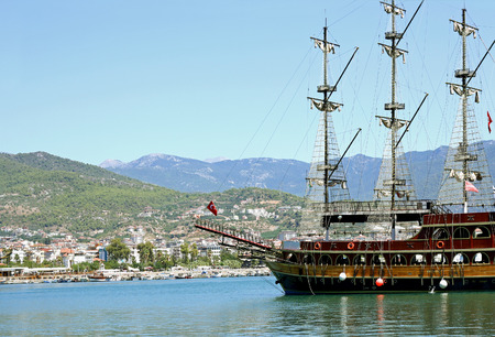 Alanya, Turkey - August 28, 2015: a large tourist ship, built in the spirit of old pirate ships sailing, sailing by the city against the mountains.のeditorial素材