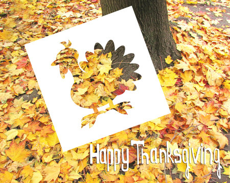 Greeting card Thanksgiving. On the background of fallen leaves-cut silhouette of a Turkey and words.