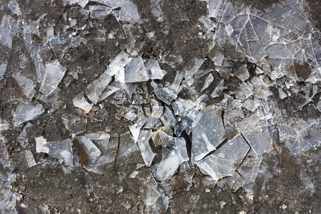 Cracked shards of ice on a dark puddle,photographed in close-up. Image a dark gray color. You can use for the background.の写真素材