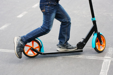 Children playing on the walk. Walks in the fresh air. A child riding on scooters.