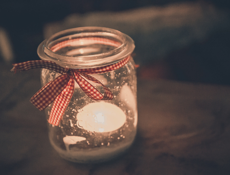 Christmas decoration jar with candle and red ribbonの写真素材