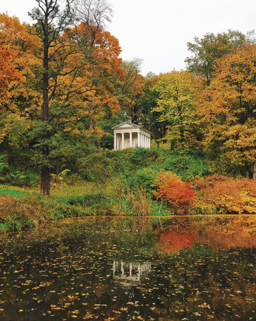 Ancient small building between trees in autumn