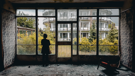 Women standing at window at the ruin old holiday resortの写真素材
