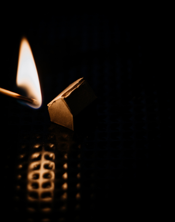 Burning paper house with matchの写真素材