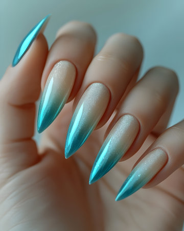 Female hand with long nails and light blue manicure holds a bottle of nail polishの素材