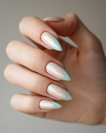 Female hand with light blue nail design. Nail polish manicure.の素材