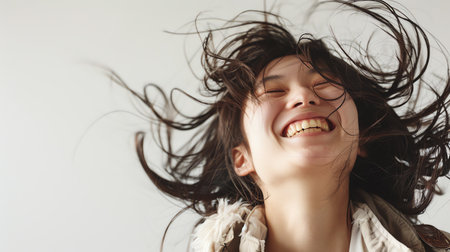 Photo pour Portrait of a happy young woman with wind blowing her hair. - image libre de droit