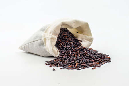 Rice berry in a wooden ladle On a white background の写真素材