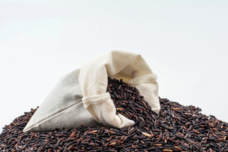 Rice berry in a wooden ladle On a white background の写真素材