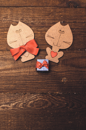 Two wooden cat with a red bow and valentine are on a wooden backgroundの写真素材