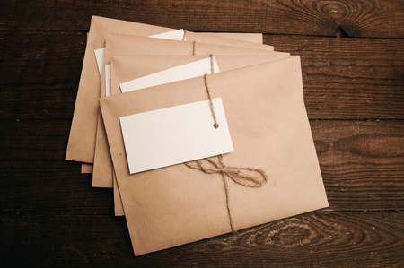 Note from a paper on a cord of an envelope from kraft paper on a wooden tableの写真素材