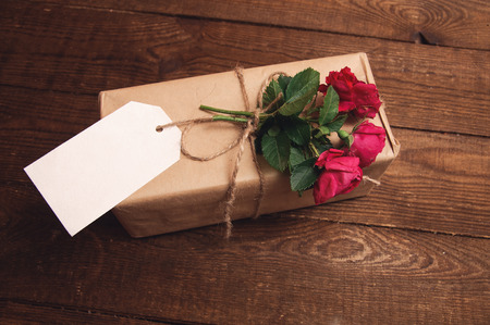 gift wrapped in kraft paper with rose flower on topの写真素材