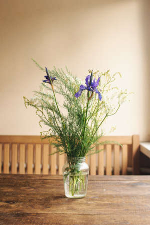 Floral colorful bouqet wildflowers on wooden table in the room.の写真素材