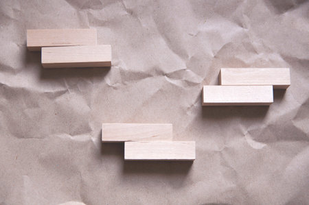 background of crumpled craft paper with wooden rectangles arranged in a certain order in a...