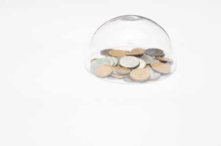 metal coins are grouped under a glass semicircle on a white background