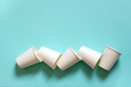 disposable white kraft paper cups stand on paper blue background