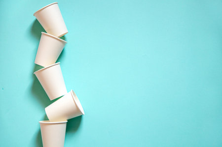 disposable white kraft paper cups stand on paper blue backgroundの写真素材