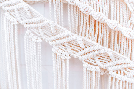 handmade macrame pattern a fragment of a wall panel in the boho style of beige cotton threads of...