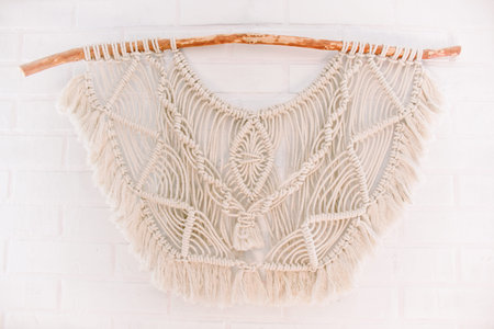 handmade macrame pattern for wall panels in boho style from beige cotton threads of natural color...