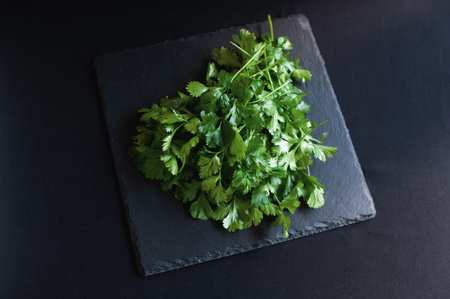 fresh dill and parsley lies on a black board