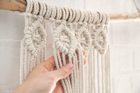 Boho wall mural made of natural color cotton threads using macrame technique for home and wedding...
