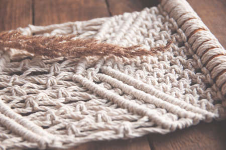 Branch of a dried marsh. Macrame handmade macrame texture. The concept of natural decor in the interior. Cotton cord and macrame decorの写真素材