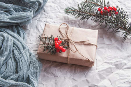 Gift box next to vintage Gauze gray and spruce leaves red berries, holiday composition on gray paperの写真素材