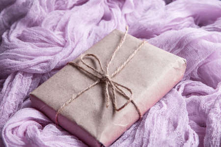 Kraft paper box next to a vintage tablecloth hand-painted with pink gauze. Boho style gauze runners, rustic tablecloth for wedding decorの写真素材