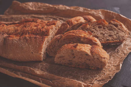 baguette of buckwheat flour without yeast on a black background, slices of sliced bread on parchment paper.の写真素材