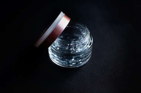 transparent jar with hyaluronic acid moisturizing gel on a black backgroundの写真素材