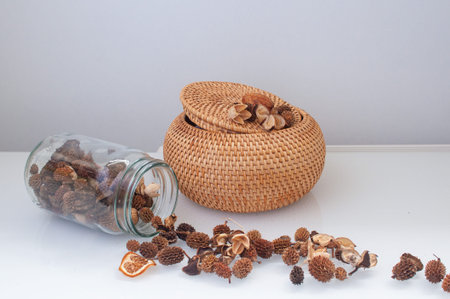 wicker straw box craft round on top with dried flowers and lavender on a white backgroundの写真素材