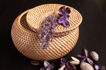 wicker rattan box craft round on top with dried flowers and lavender on a black backgroundの写真素材