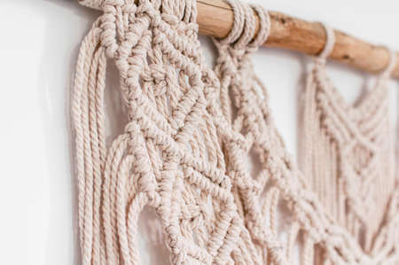 wall decor of woven threads in the style of macrame on a white backgroundの写真素材