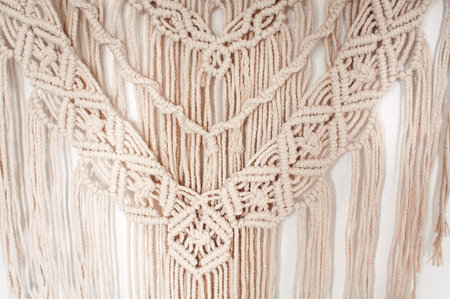 Fragment of a wall decor made of woven threads in macrame style on a white backgroundの写真素材