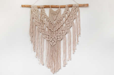 Wall decor of woven threads in style of macrame on a white backgroundの写真素材
