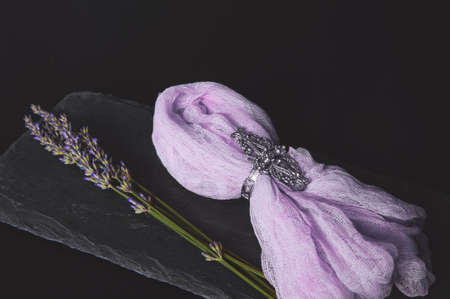 Bouquet of lavender on a black board made of raw stone with a napkin on a dark backgroundの写真素材