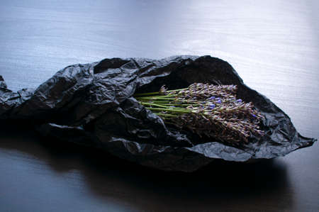 Bouquet of fragrant fresh lavender flowers on dark crumpled wrapping paper backgroundの写真素材
