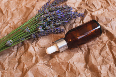 glass jar with lavender oil with fresh lavender flowers on kraft paper.の写真素材