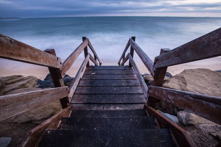Wooden staircase down to the beach at sunriseの写真素材