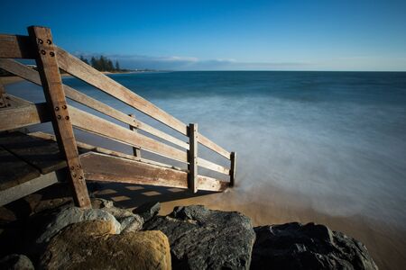 Wooden staircase down to the beach at sunriseの写真素材