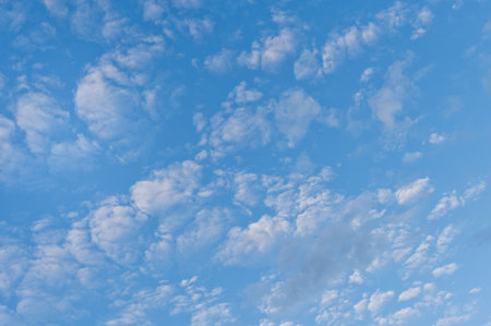 A smooth blue cyan sky with scattered clouds throughout