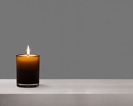 Burning candle on a white table against a gray background. 3d renderingの写真素材