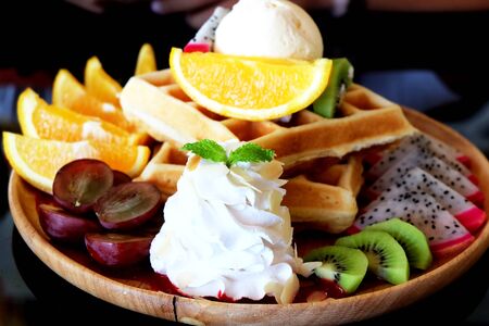 Waffle ice cream with mix fruit. Orange and grape fruit with whipped cream.の写真素材