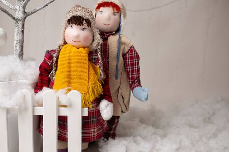 Two plush children standing by the fence in a Christmas arrangementの写真素材