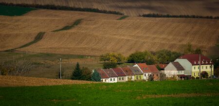 Terraced village buildings against the backdrop of rolling Moravian fieldsの写真素材
