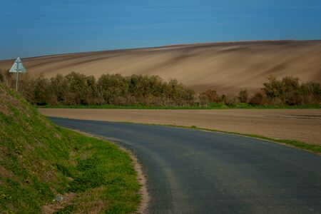 Road running through beautiful Moravian fields at autumn time