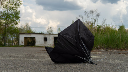 A broken umbrella lies on the asphalt after being destroyed by a strong wind. Polandの写真素材